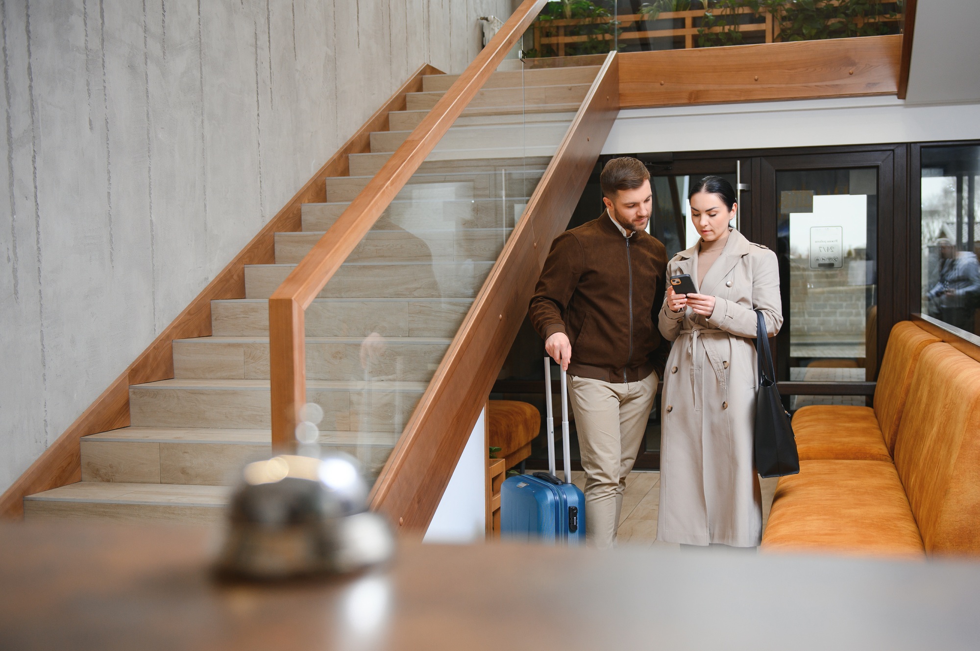 Young couple near reception desk in hotel. Young couple leaving hotel